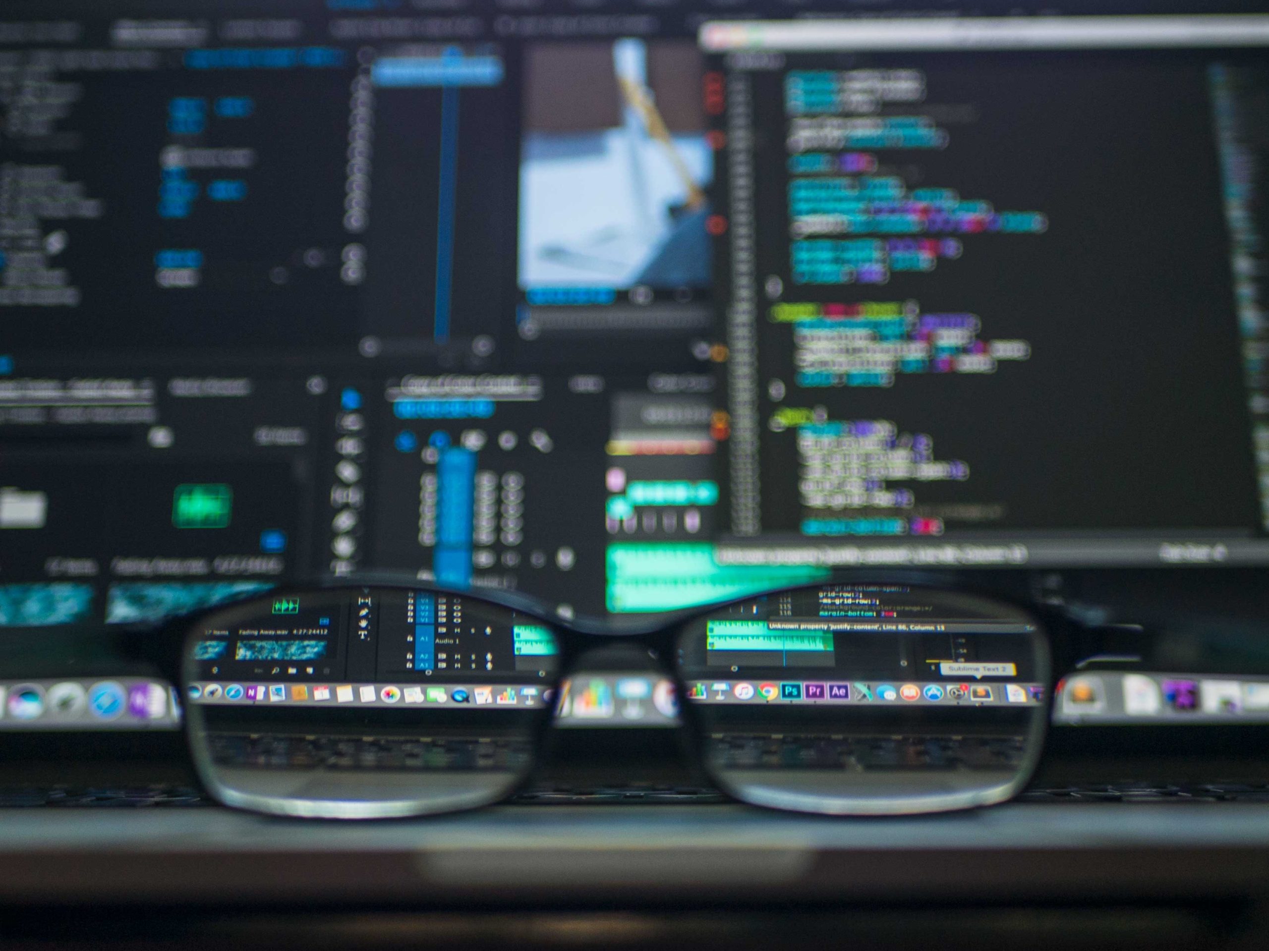 glasses in front of a screen with code