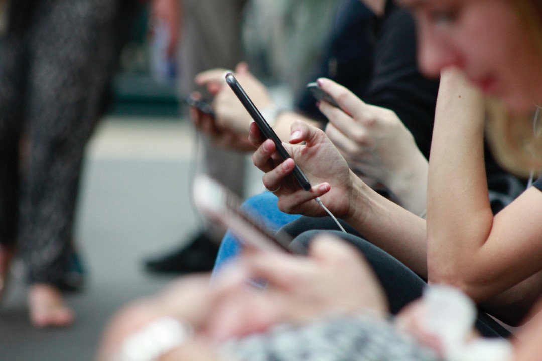 People looking on a train looking at phones